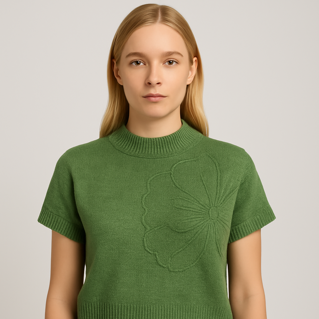 Top de punto sin mangas verde claro con diseño floral en relieve, combinado con pantalones blancos