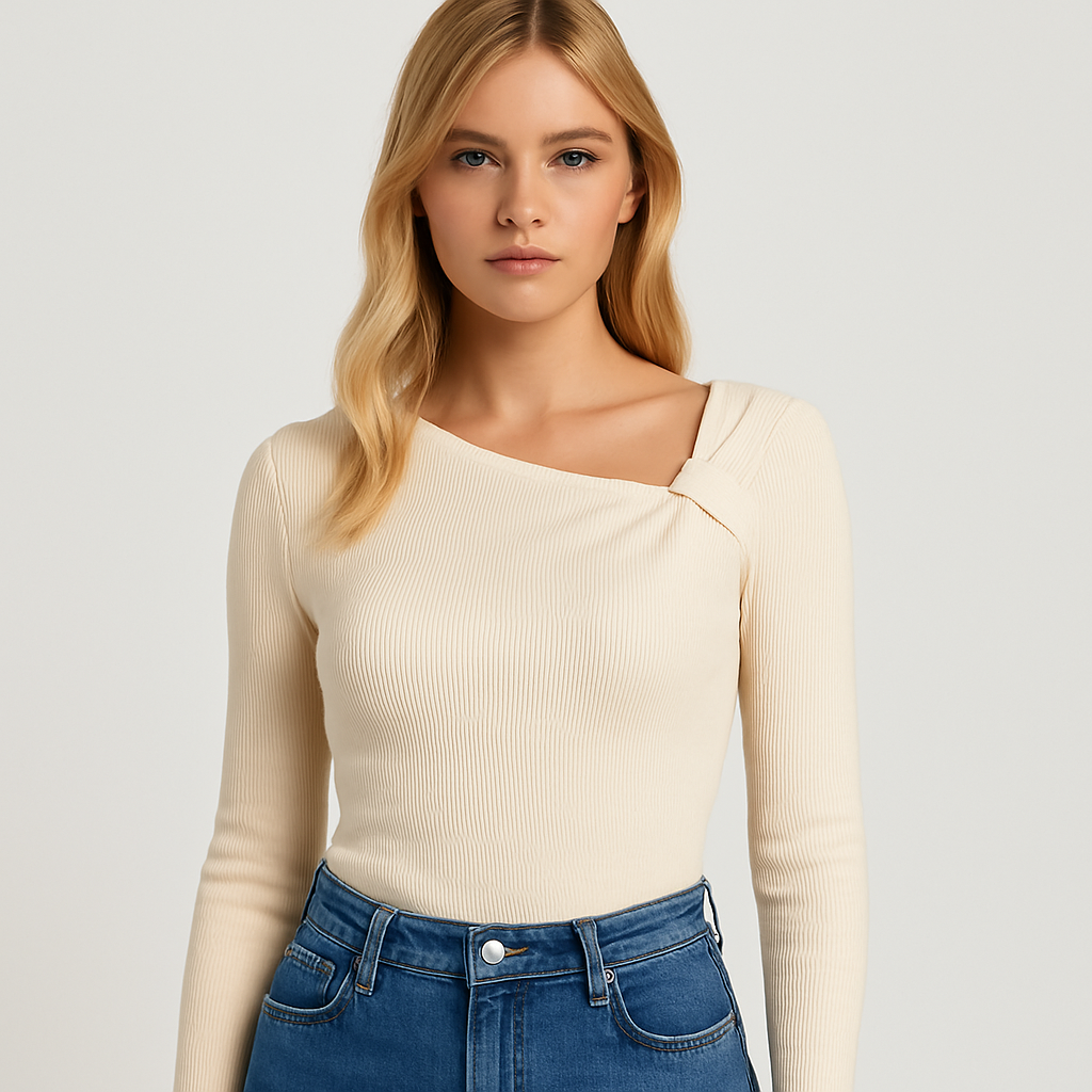 Top de punto acanalado color crema con escote asimétrico y silueta entallada, combinado con vaqueros